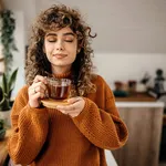 Portrait of young beautiful woman having a tea in her apartment