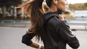 Strong fitness woman running outdoors by street.