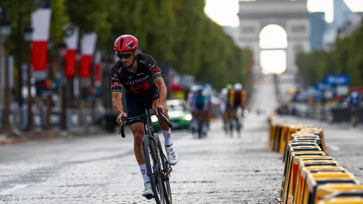 Julian Alaphilippe eenzaam op de Champs-Élysées voor de Arc de Triomphe op de slotdag van de Tour 2026.