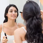 Woman applying mascara