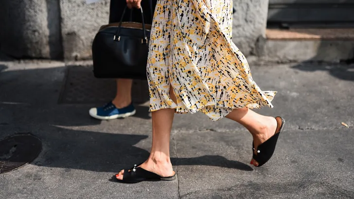 Foto van vrouw in outfit voor zomer met lange jurk en zomerschoenen.