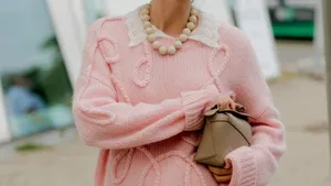 Vrouw in roze lente trui geniet van haar langdurige parfum.
