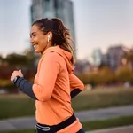 Happy female athlete running while exercising outdoors.