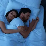 Lovely couple sleeping together in bed at night, top view