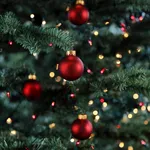 Glowing Christmas tree decorated with red and gold ornament ball