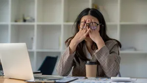 tired business woman sleepy and bored from sitting at a desk for a long time and has office syndrome