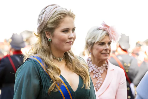 Foto van prinses Amalia met een Fabienne Delvigne hoed, met op de achtergrond prinses Laurentien tijdens Prinsjesdag 2022.