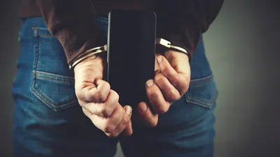 Gehandboeide man die telefoon vastheeft.