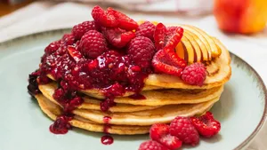 Bord vol pannenkoeken en vers fruit.