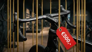 Een high-end geïntegreerd racestuur met een prijskaartje van €500,- is gevangen in een gouden kooi, wat de dure 'gijzeling' door fietsmerken symboliseert.