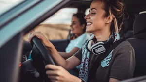 Twin sisters driving car and enjoying road trip