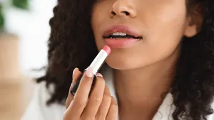 Vrouw brengt dupe voor dure lipstain aan op lippen.