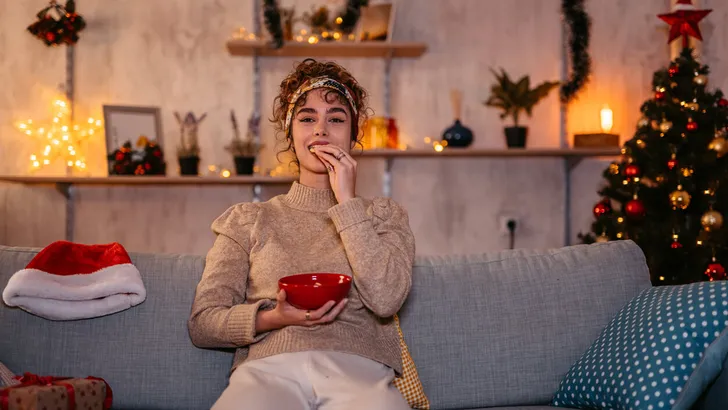 Woman watching movie and eating snacks at Christmas