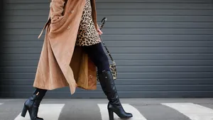 Stylish woman in black shoes walking across the street