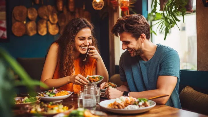 Young couple eating indian food at restaurant. Couple on date night with delicious food. Generative AI