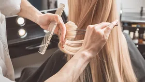 Hairdresser is cutting long hair in hair salon