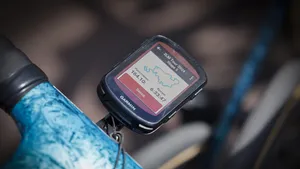 Fietscomputer van Garmin op een racefiets met een routekaart en ritstatistieken zichtbaar op het scherm.