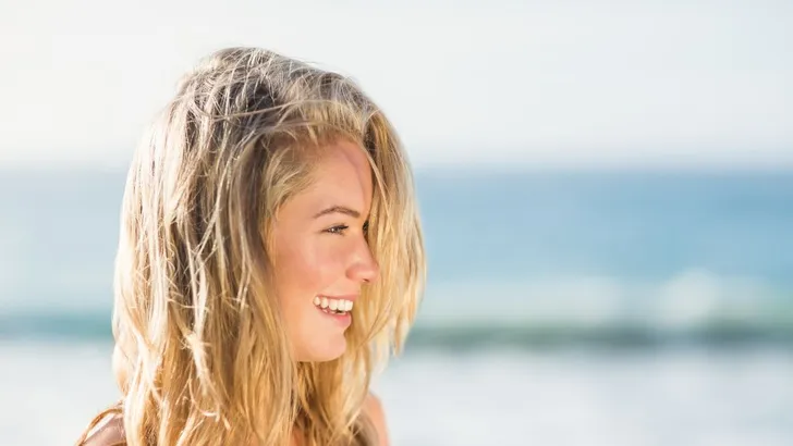 Blonde vrouw op het strand.