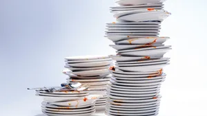 Dirty plates, glasses, cutlery on white background.