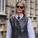 Vrouw met zwart leren gilet in de straten van Kopenhagen tijdens Copenhagen Fashion Week