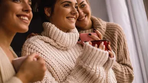 Low angle view of three happy women looking through the window