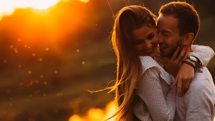 passionate hug of a couple in love on the shore of an evening la