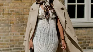 Vrouw straalt in stijlvolle jurk tijdens fashion week momentje.