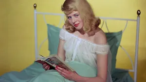 circa 1961:  A young woman unwinds before sleep boek