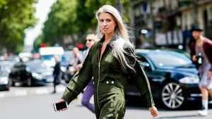 Sarah Harris met grijs lang haar op straat in groen pak