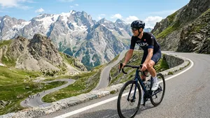 Mannelijke wielrenner met helm rijdt ontspannen en op een lichter verzet een steile bergpas in de Alpen omhoog.