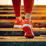 Urban fitness. Young female runner jogging up in city at sunset active and healthy lifestyle. Fit woman upstairs in park enjoying morning sunlight and active side of outdoor exercise
