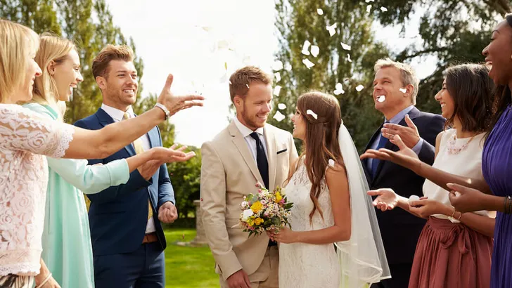 Guests Throwing Confetti Over Bride And Groom At Wedding