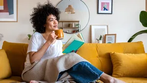Vrouw aan het genieten in haar woning tussen allerlei woonaccessoires.