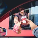 Bangkok, Thailand - Mar 4, 2017: customer receiving hamburger and ice cream after order and buy it from McDonald's drive thru service