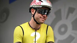 Wout van Aert in het geel-zwarte shirt van zijn ploeg, waarbij de sponsorlogo's op zijn borst zijn vervangen door een groot, wit vraagteken.