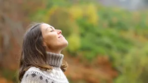 Middle aged woman breathing fresh air in a forest