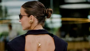 Vrouw met grote statement oorbellen tijdens Fashion Week, in stijl.