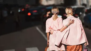 De Weekendtips van Beau Monde voor week 10 2025. – Foto van twee stijlvolle vrouwen in lichtroze bomberjacks in de zon op straat.