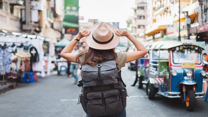 Back view Asian woman tourist backpacker travel in Khao San road, Bangkok, Thailand