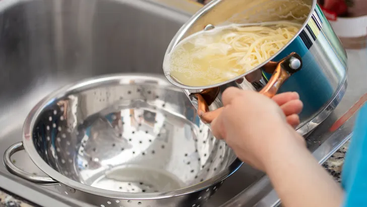 draining the water from the spaghetti