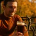Wielrenner geniet in de herfstzon van een glas donker herfstbockbier na het fietsen.