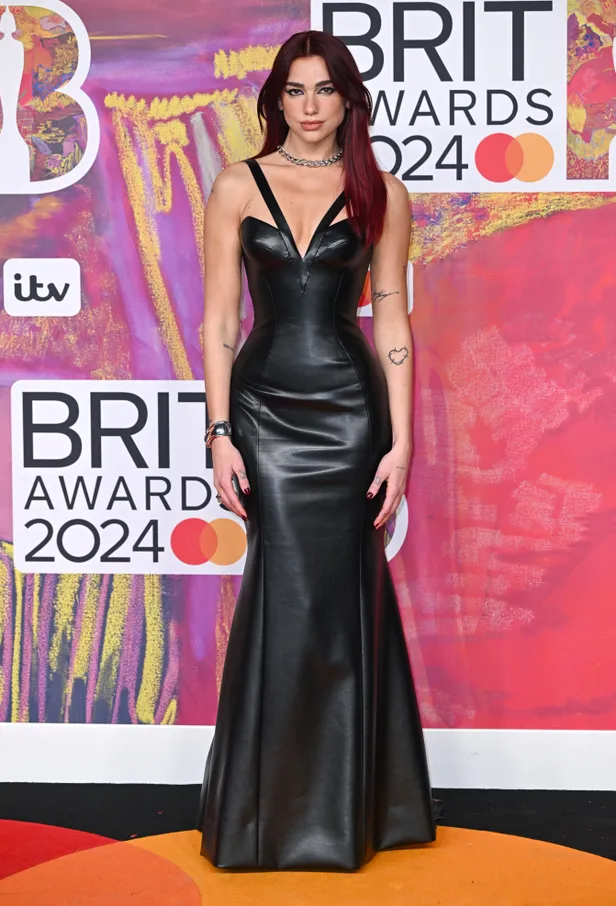 Dua Lipa in een zwarte leren Versace-japon bij de Brit Awards 2024.