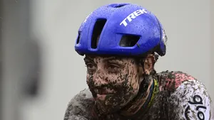 Lucinda Brand zit onder de modder tijdens een zware veldrit, met een vermoeide blik onder haar blauwe Trek-helm.