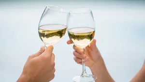 Twee glazen proosten met witte wijn