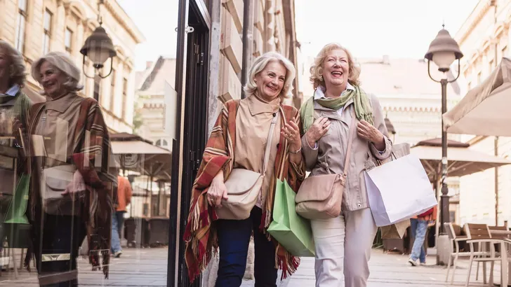 Social Seniors. Senior women shopping, having fun and laughing on the street