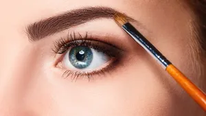 Beautiful female eyes with make-up and brush