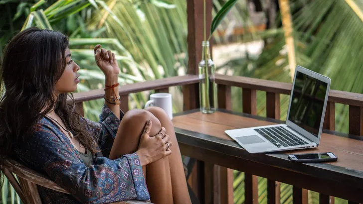Portrait of young brunette woman freelancer working with laptop