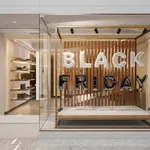 Exterior Of Clothing Store With White And Black Colored Black Friday Text Balloons