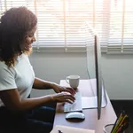 Smiling young African American Woman working on Computer.