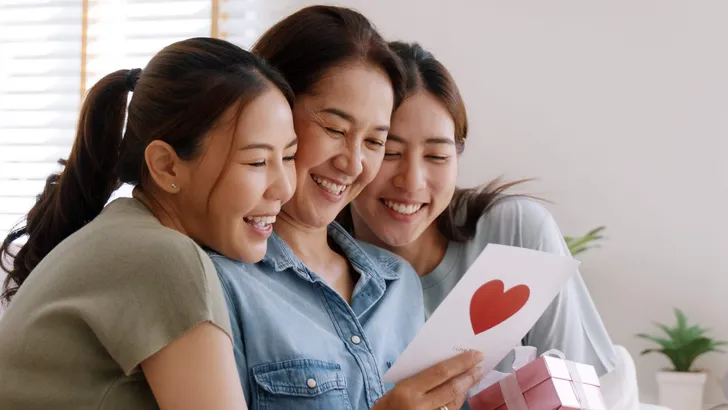 Mother day two grown up child cuddle hug give flower gift box re